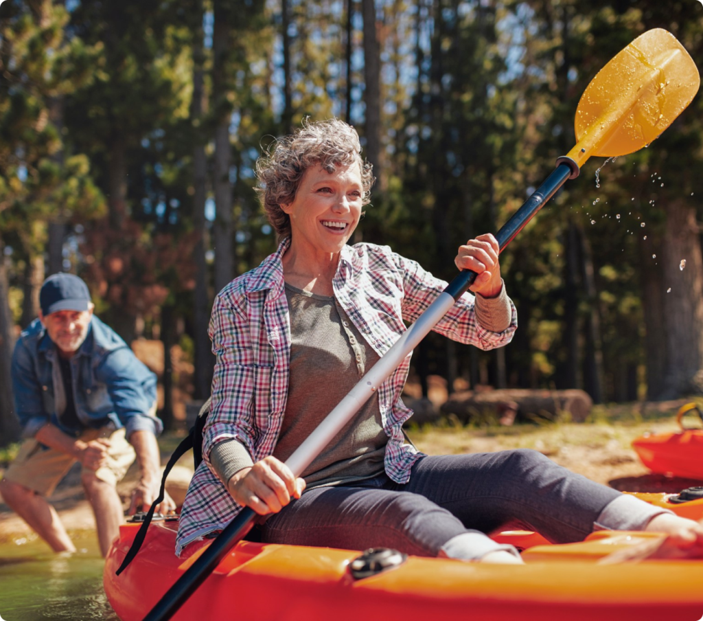 Woman kayaking with man behind her