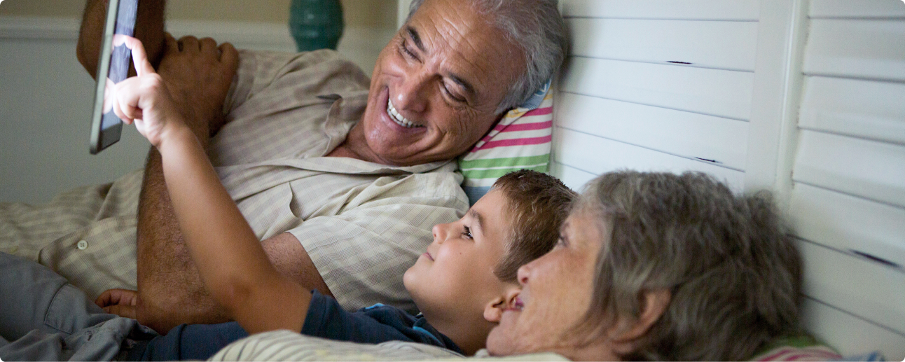 Family of two older adults looking at ipad