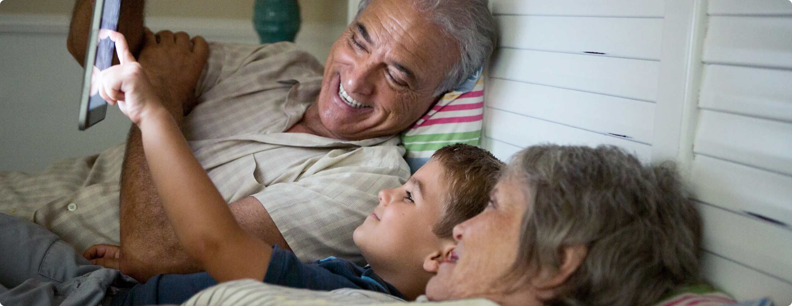 man, woman, and child looking at tablet