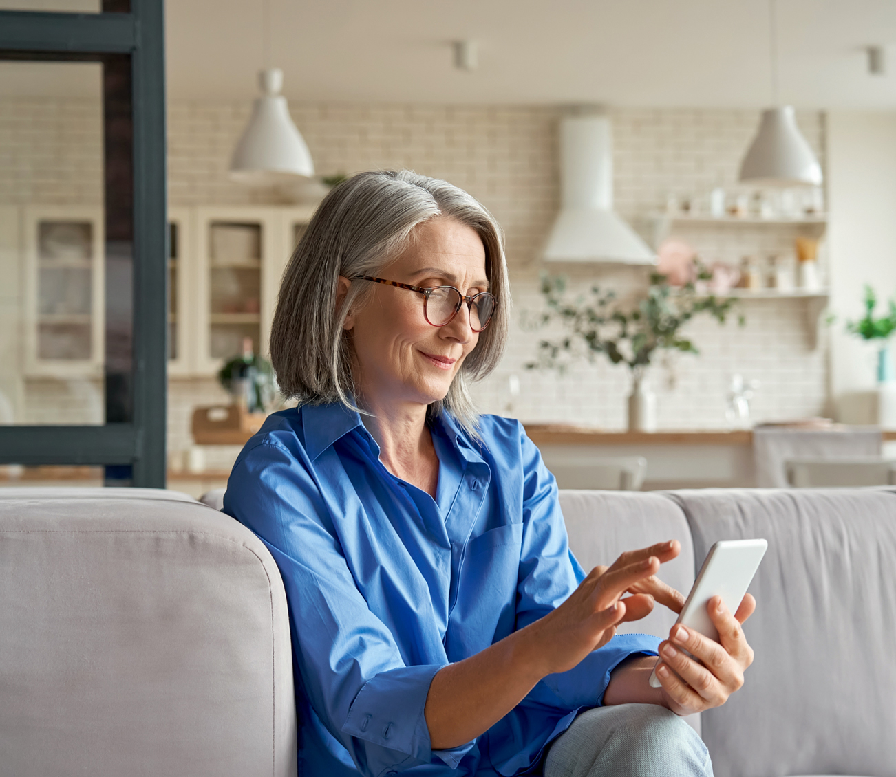 Older woman looking at cell phone in living room
