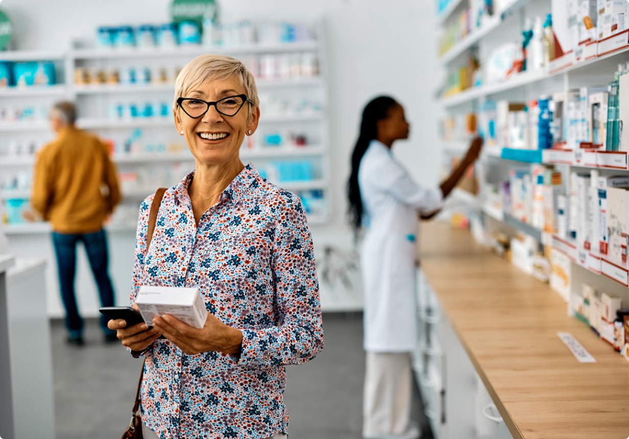 Senior woman at pharmacy smiling and holding a prescription