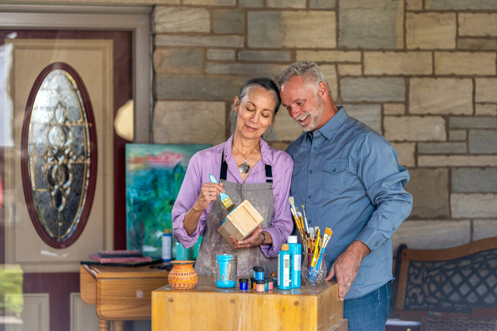 Older couple working on a painting project on front porch