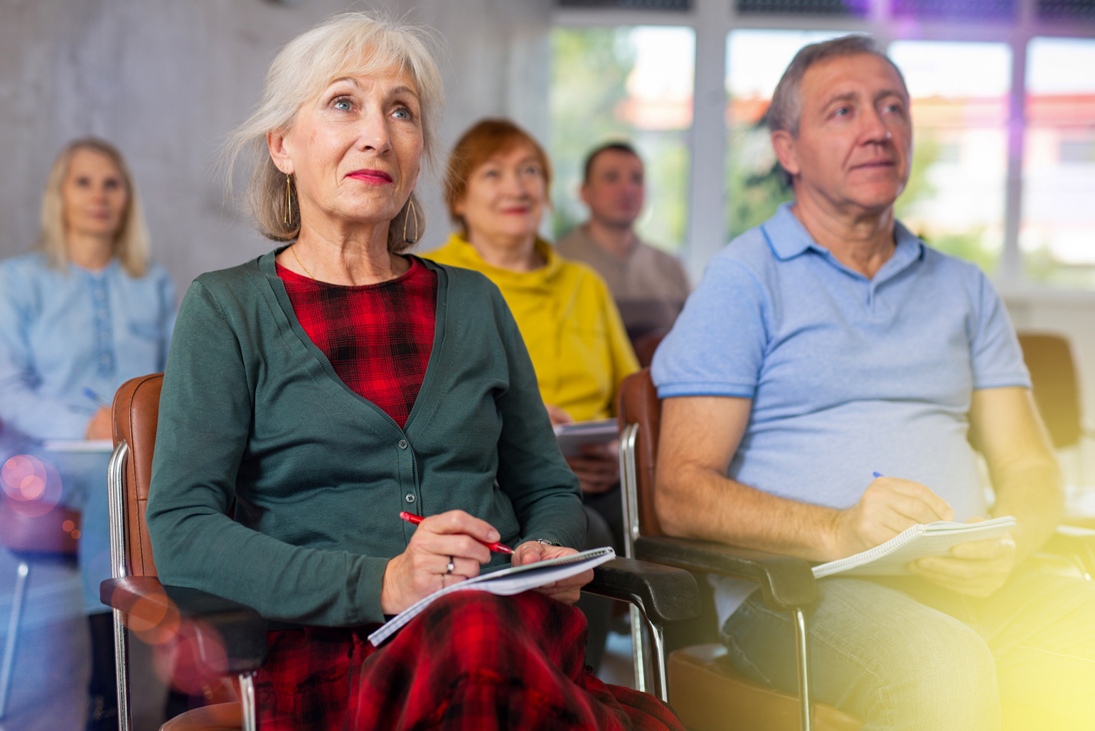 Older adults sitting and taking notes at seminar