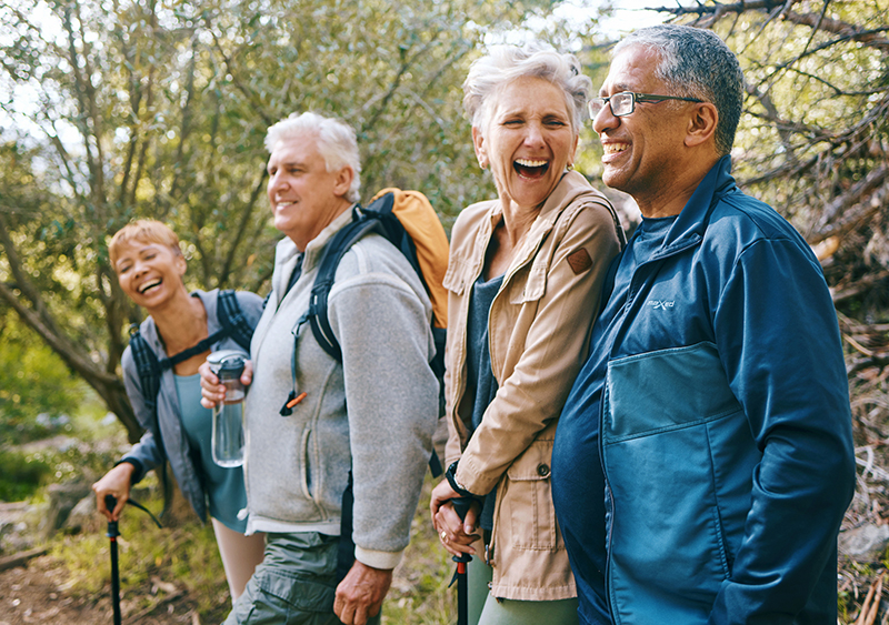 Group of older adults hiking and laughing